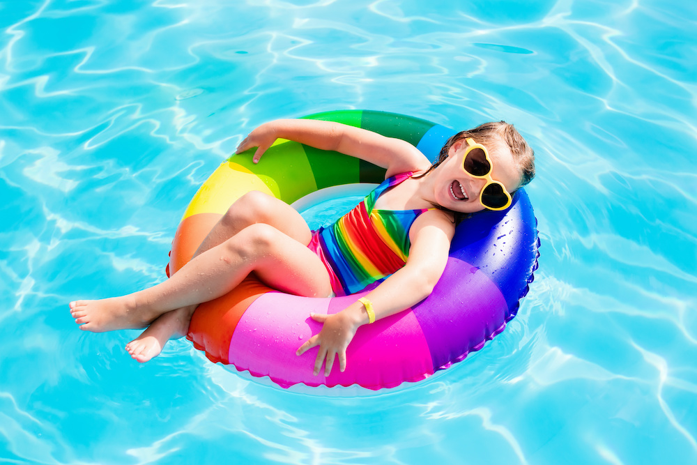 Child with toy ring in swimming pool